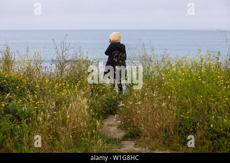 Woman back facing the ocean in Pigeon Point Light Station State Historic Park, Pescadero, California, USA Stock Photo