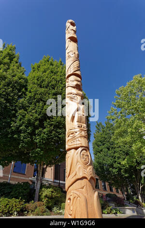 New Kwakiutl style Reconciliation totem pole carved by Xwalacktun and James Harry outside the Vancouver School Board building, Vancouver, BC, Canada Stock Photo