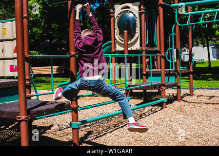 A boy slides on a zip line on a playground on a warm summer day. Stock Photo