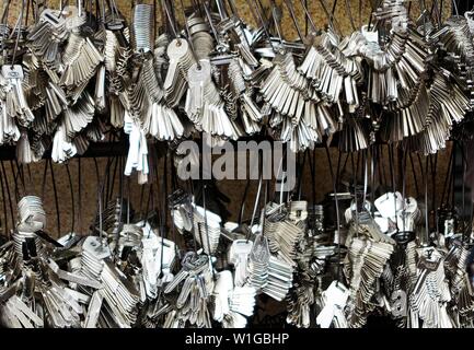 Close up of countless silver key blanks hanging on rings at wall for duplication - Bangkok, Thailand Stock Photo