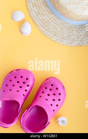 San Diego, USA,May 10, 2019. Flat lay composition with beach shoes, hat, seashells and space for text on yellow background.sandals with seashell Stock Photo