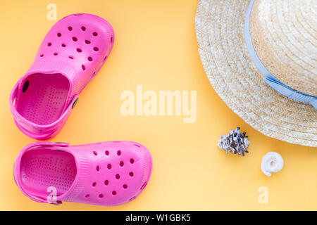 San Diego, USA,May 10, 2019. Flat lay composition with beach shoes, hat, seashells and space for text on yellow background.sandals with seashell Stock Photo