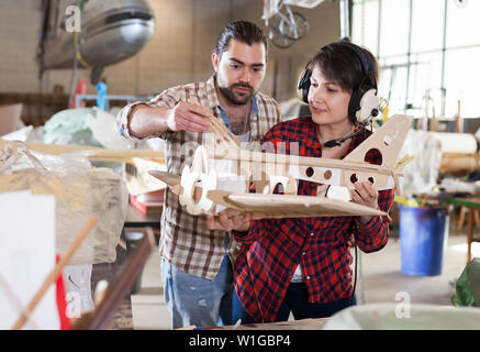 Team of aircraft enthusiasts working in workshop on creating of airplane models Stock Photo