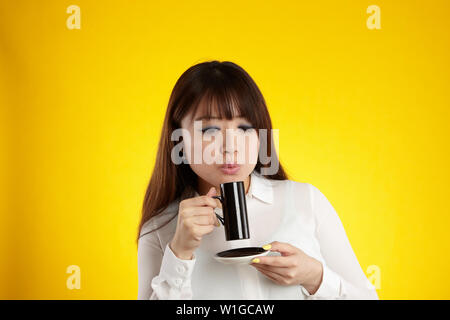asian woman drinking from espresso cup Stock Photo