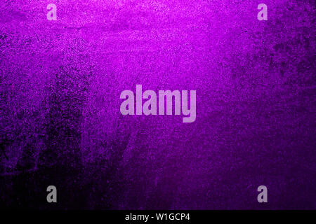 Drops of water flow on the background of a dark purple window. Background of dark purple lights. Dark purple background for an inscription. Stock Photo