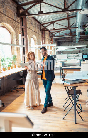 Two interior designers. Two interior designers standing in spacious office and speaking about project Stock Photo
