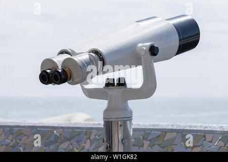 Binocular telescope on a rotating base mounted on an outdoor touristic viewpoint Stock Photo