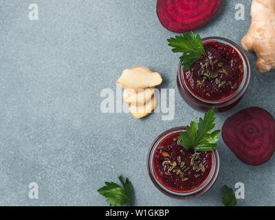 Fresh beetroot and ginger root smoothie. Beetroot smoothie in glass jar on gray table. Shallow DOF. Copy space for text. Clean eating and detox concept, recipe idea. Top view or flat lay. Stock Photo