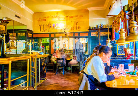 VIENNA, AUSTRIA - FEBRUARY 18, 2019: The tourists in traditional Viennese restaurant rest while waiting for their order, on February 18 in Vienna. Stock Photo