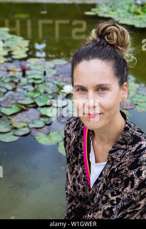 Tourist woman sit in the fountain of Beverly Hills Sign, Beverly Hills, Los Angeles, California, USA Stock Photo