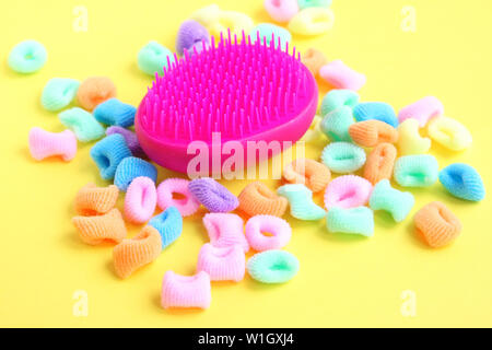 Premium Photo  Bright multicolored comb on colored rubber bands for hair  on a white background.