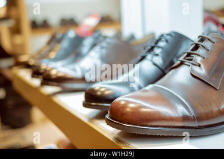 leather men's shoes business class in the store. Brown leather boots for men. Handmade leather shoes on the showcase. a number of men's shoes in the s Stock Photo