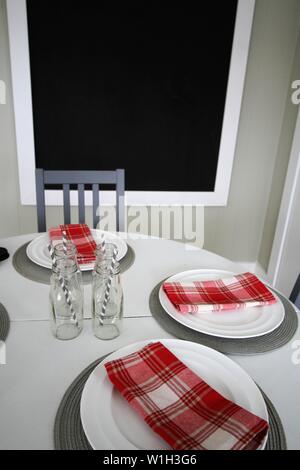 Round table with place settings and blackboard Stock Photo