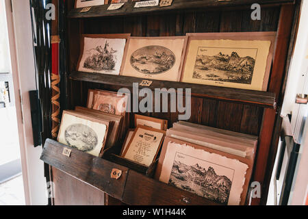 Bled, Slovenia - September, 8 2018: Close up of ancient souvenir post cards with landscapes printed on reconstructed Gutenberg's printing machine. Sol Stock Photo