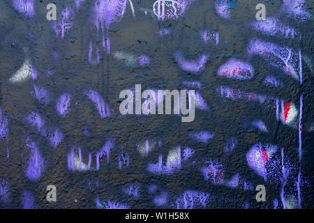 Fragment of dirty and stained wall with old chipped paint in purple colors, scratch, grunge texture close-up. Modern abstract background Stock Photo