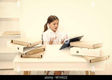 Oh no, the text is too long. Schoolgirl reading school book at desk. Little girl reading lesson book in school. Small school child have literature lesson. Adorable pupil develop reading skills. Stock Photo