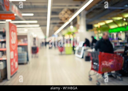 Blurred brightly background of the supermarket. Cashier, gueues at the store. Sale time concept. Stock Photo