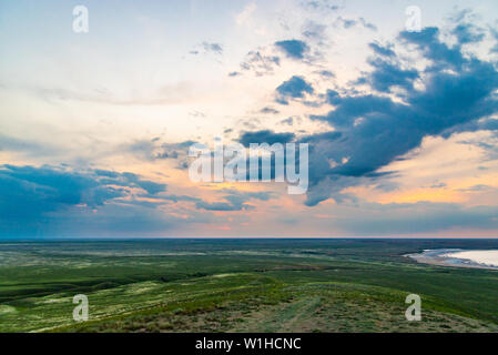 Scenic sunset with clouds in sky in steppe. Stock Photo