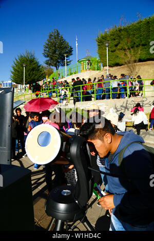 La Paz, Bolivia 2nd July 2019: A man observes a partial eclipse of the sun through a telescope at an eclipse watching event near the city centre. In La Paz the eclipse lasted for about 2 hours 10 minutes with about 55% coverage at its maximum. Stock Photo