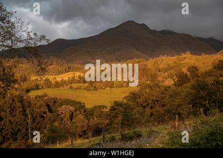 Multiple exposure of a valley and the Iguaque mountain under an overcasted sky illuminated by the sunset, in the central Andean mountains of Colombia. Stock Photo