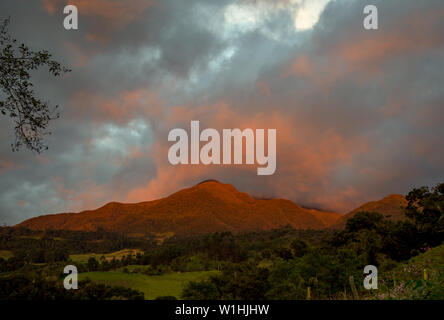 Multiple exposure of Iguaque mountain painted in red by the light of the sunset in an overcasted sky, at the central Andean mountains of Colombia. Stock Photo