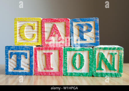 Educational toy cubes with letters organised to display word CAPTION - editing metadata and Search engine optimisation concept Stock Photo