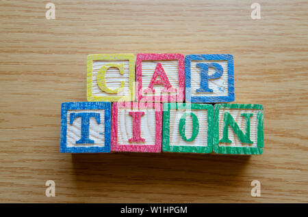 Educational toy cubes with letters organised to display word CAPTION - editing metadata and Search engine optimisation concept Stock Photo