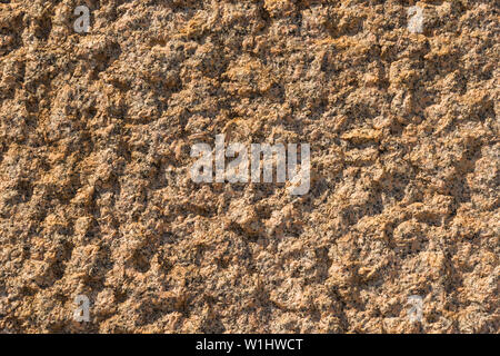 Yellow and orange granite wall with quarts and rough surface as background Stock Photo