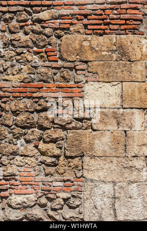 Composite old stone and bricks wall with rough surface as background Stock Photo