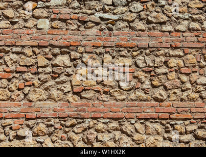 Composite old stone and bricks wall with rough surface as background Stock Photo