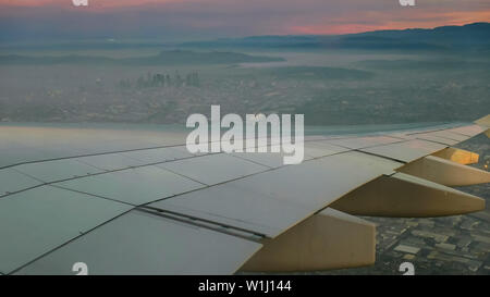 aerial view of sunrise and plane wing over los angeles Stock Photo