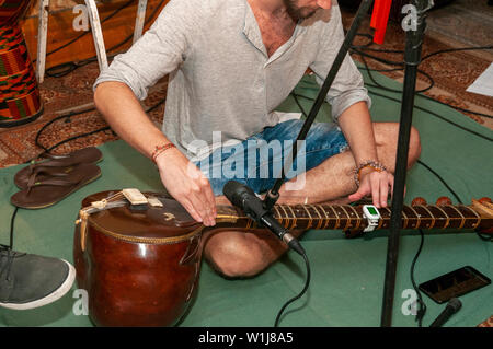 Young Sitar player tunes his instrument Stock Photo