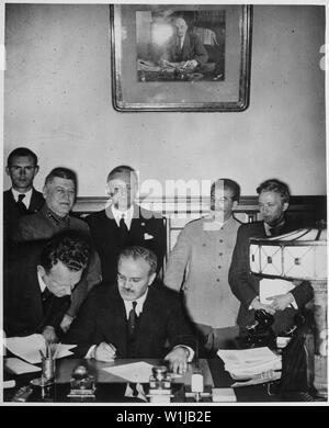 Soviet Foreign Minister Molotov signs the German-Soviet Boundary and Friendship Treaty; Joachim von Ribbentrop and Josef Stalin stand behind him, Moscow, September 28. 1939. Von Ribbentrop Collection., ca. 1946 - ca. 1946   Original incorrect title:   Soviet Foreign Minister Molotov signs the German-Soviet non-aggression pact; Joachim von Ribbentrop and Josef Stalin stand behind him, Moscow, August 23. 1939. Von Ribbentrop Collection., ca. 1946 - ca. 1946; General notes:  Use War and Conflict Number 990 when ordering a reproduction or requesting information about this image. Stock Photo