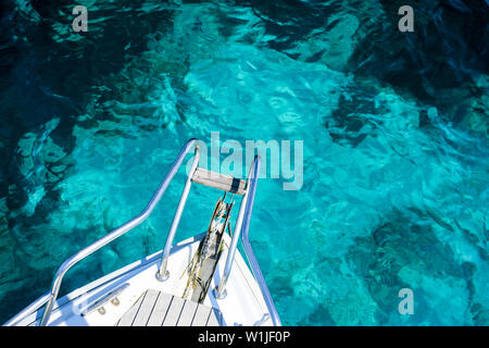 (Selective focus) Stunning view of a bow of a yacht sailing on a beautiful turquoise and transparent sea. Costa Smeralda (Emerald Coast) Sardinia. Stock Photo