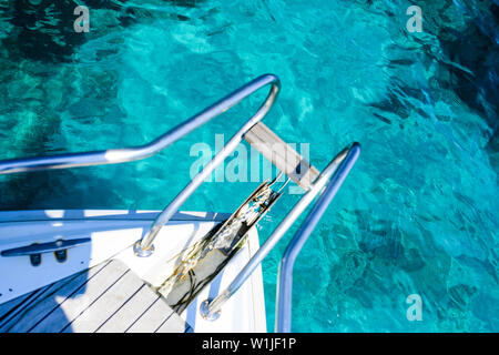 (Selective focus) Stunning view of a bow of a yacht sailing on a beautiful turquoise and transparent sea. Costa Smeralda (Emerald Coast) Sardinia. Stock Photo