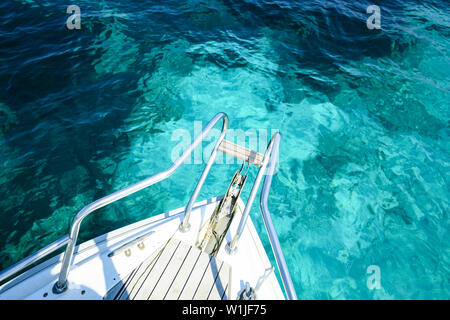 (Selective focus) Stunning view of a bow of a yacht sailing on a beautiful turquoise and transparent sea. Costa Smeralda (Emerald Coast) Sardinia. Stock Photo