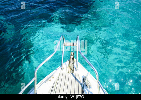 (Selective focus) Stunning view of a bow of a yacht sailing on a beautiful turquoise and transparent sea. Costa Smeralda (Emerald Coast) Sardinia. Stock Photo
