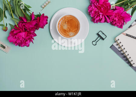 Creative frame with coffee, peonies and feminine accessories on the turquoise color background Stock Photo