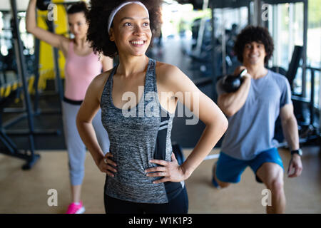 Happy gorup of healthy people training in gym Stock Photo