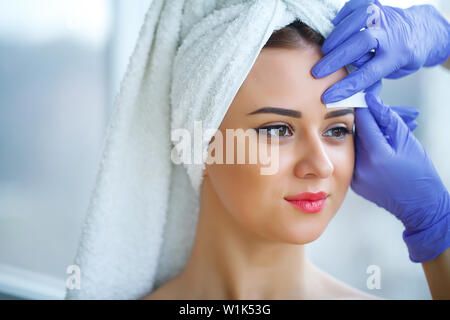 Skin care. Experienced cosmetician pulling out brows Stock Photo