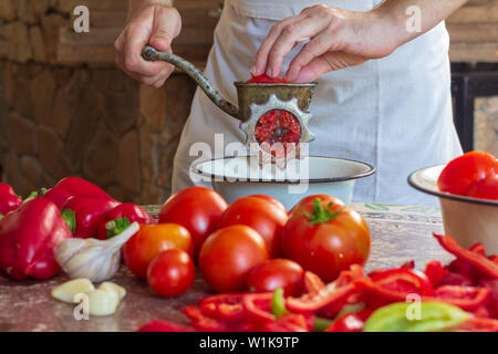 Manual vintage meat grinder and ripe tomatoes on the table. Making homemade  tomato sauce. Use of outdated kitchen utensils Stock Photo - Alamy