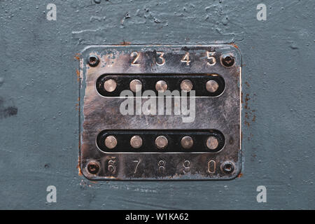 Number buttons to unlock the door lock. Panel with numbers on the old metal door. Unlocker buttons on metal door. Steel numeric keyboard Stock Photo