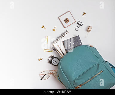 Student's backpack with different stationery and study supplies on the white background, top view. Back to school concept. Stock Photo