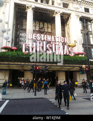 London, United Kingdom - December 15 2014:   Shoppers pass outsiide Selfridges with its Destination Chritmas campaign sign Stock Photo