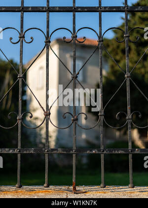 rusty metal gate and a big house in Cres (Croatia) in the evening sun Stock Photo