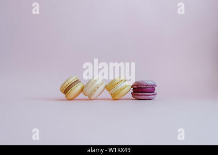 Beautiful tasty color macarons with purple accent on pink background. Stock Photo