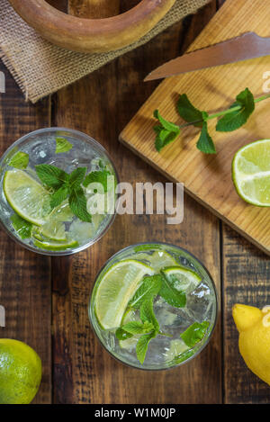 Mojito cocktail on a wooden table with its peppermint,lemon and lime ingredients Stock Photo