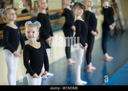 Little girls at the ballet machine. Lesson choreography. Young ballerinas.. Training of the initial group on gymnastics.Acrobatics lesson Stock Photo