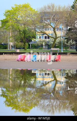 A row of colourful muskoka chairs stand out on a flooded Woodbine Beach. Stock Photo