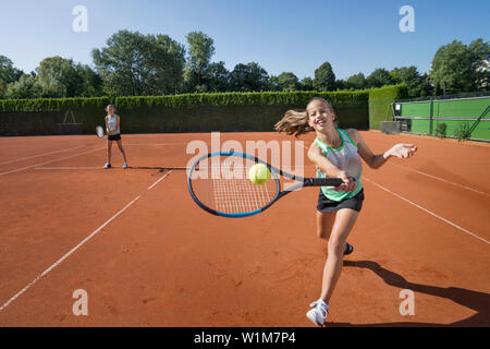 Girls playing tennis on a sunny day, Bavaria, Germany Stock Photo